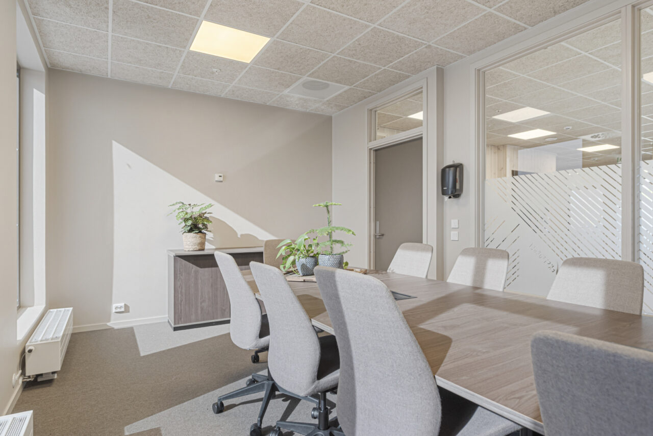møterom med bord og stoler og en skjenk med blomster på