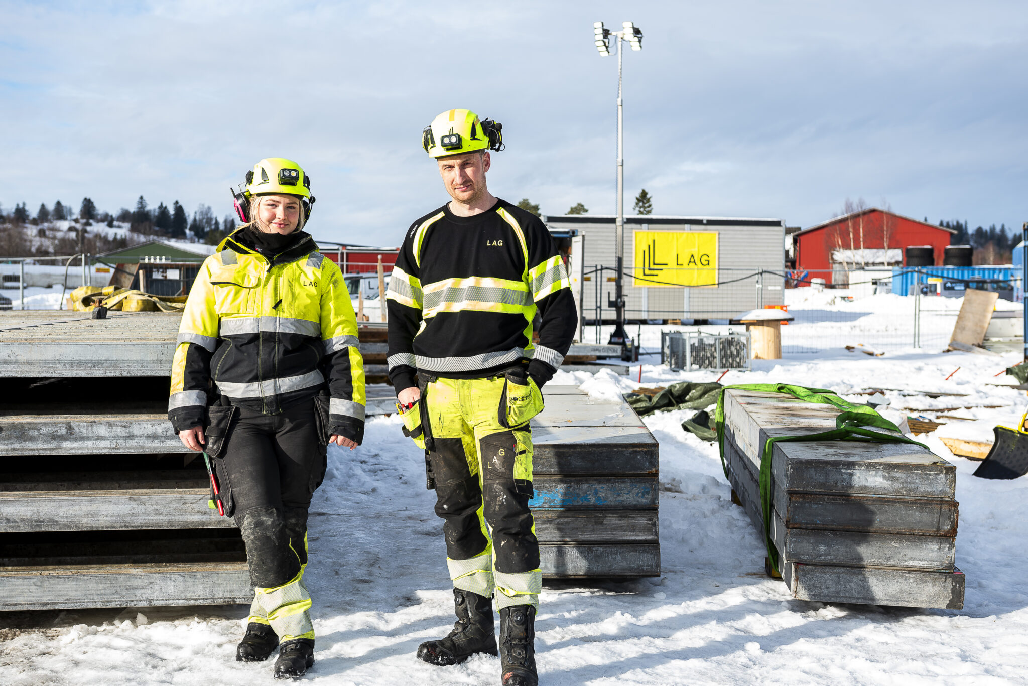 Kvinne og mann i arbeidsklær står foran betongheller