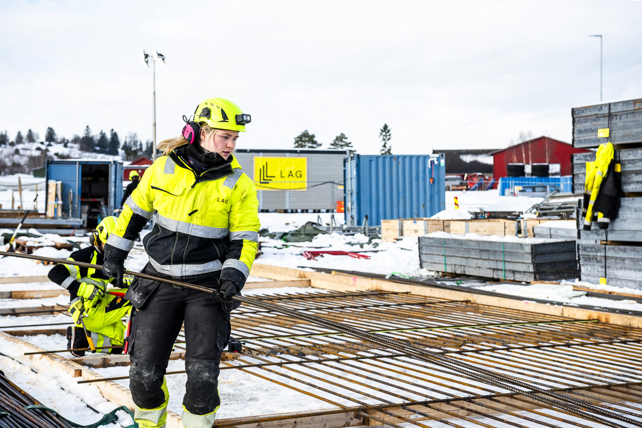 dame i arbeidsklær jobber med armeringsjern