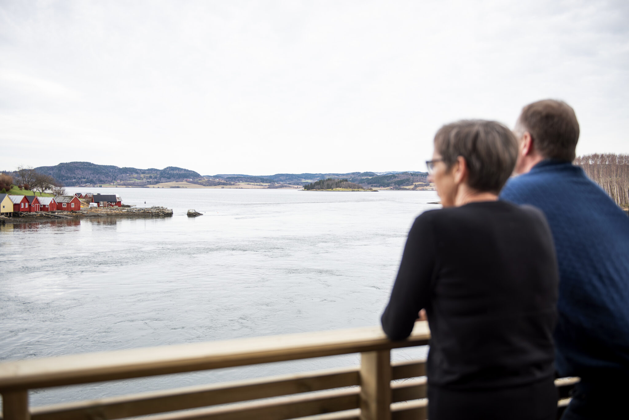 Mann og kvinne står med ryggen til og ser utover fjorden