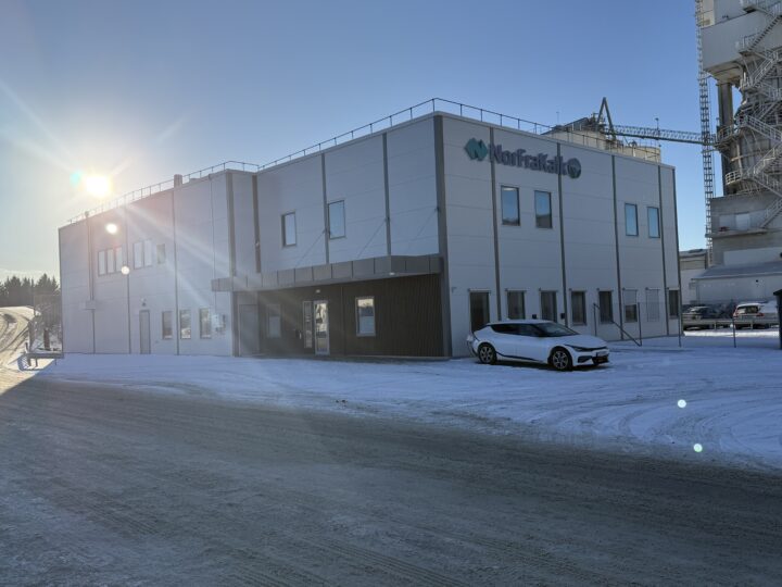 Et hvitt bygg i stål med en bil parkert utenfor. På veggen er logoen til Norfrakalk.