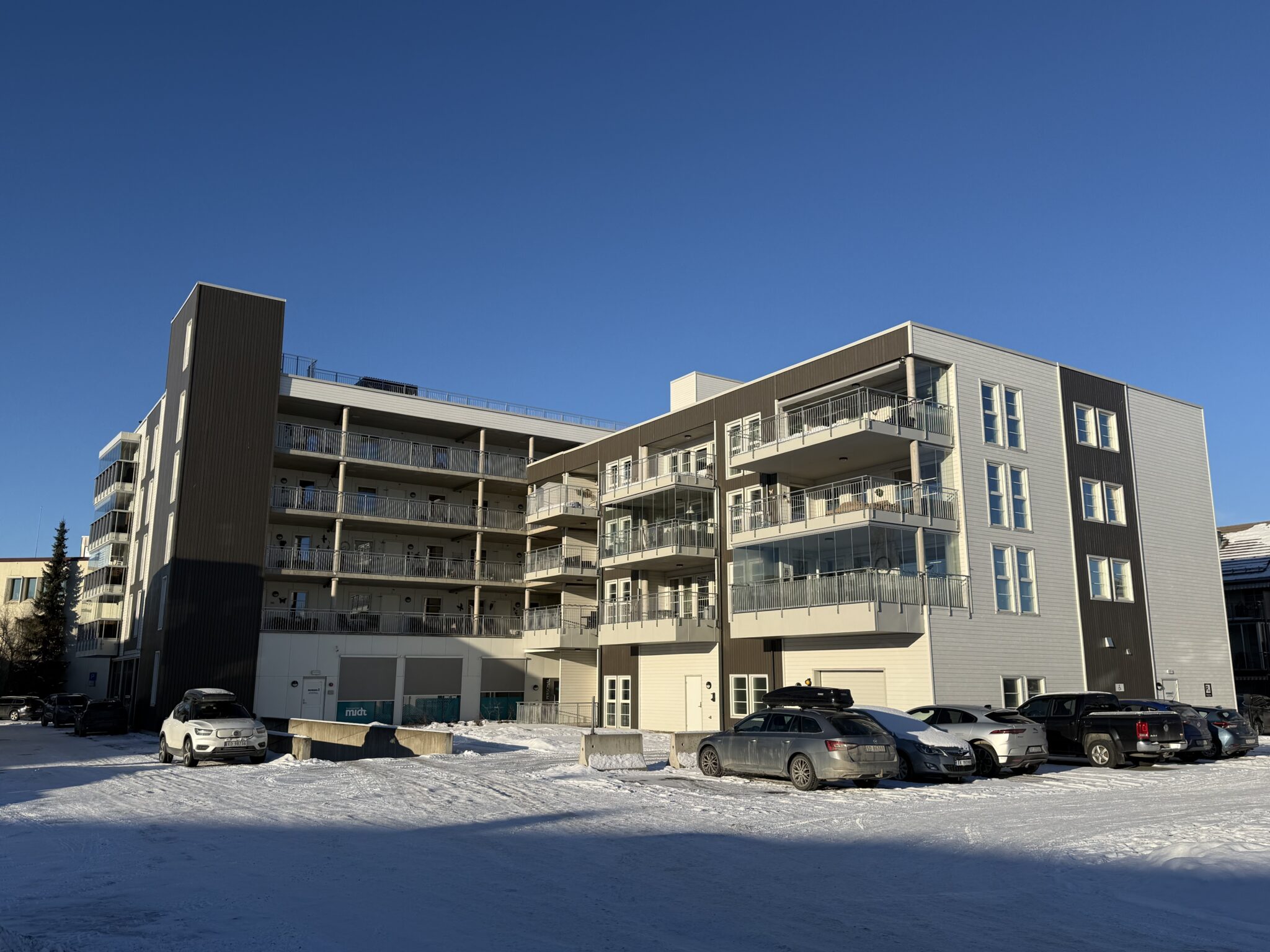 Leilighetsbygg i strålende vintersol.