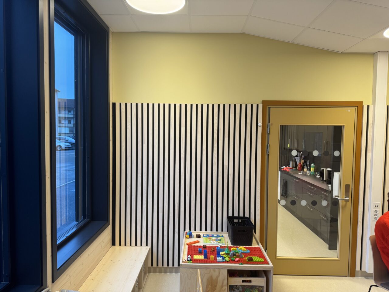 Et bord med lego står foran en spilevegg