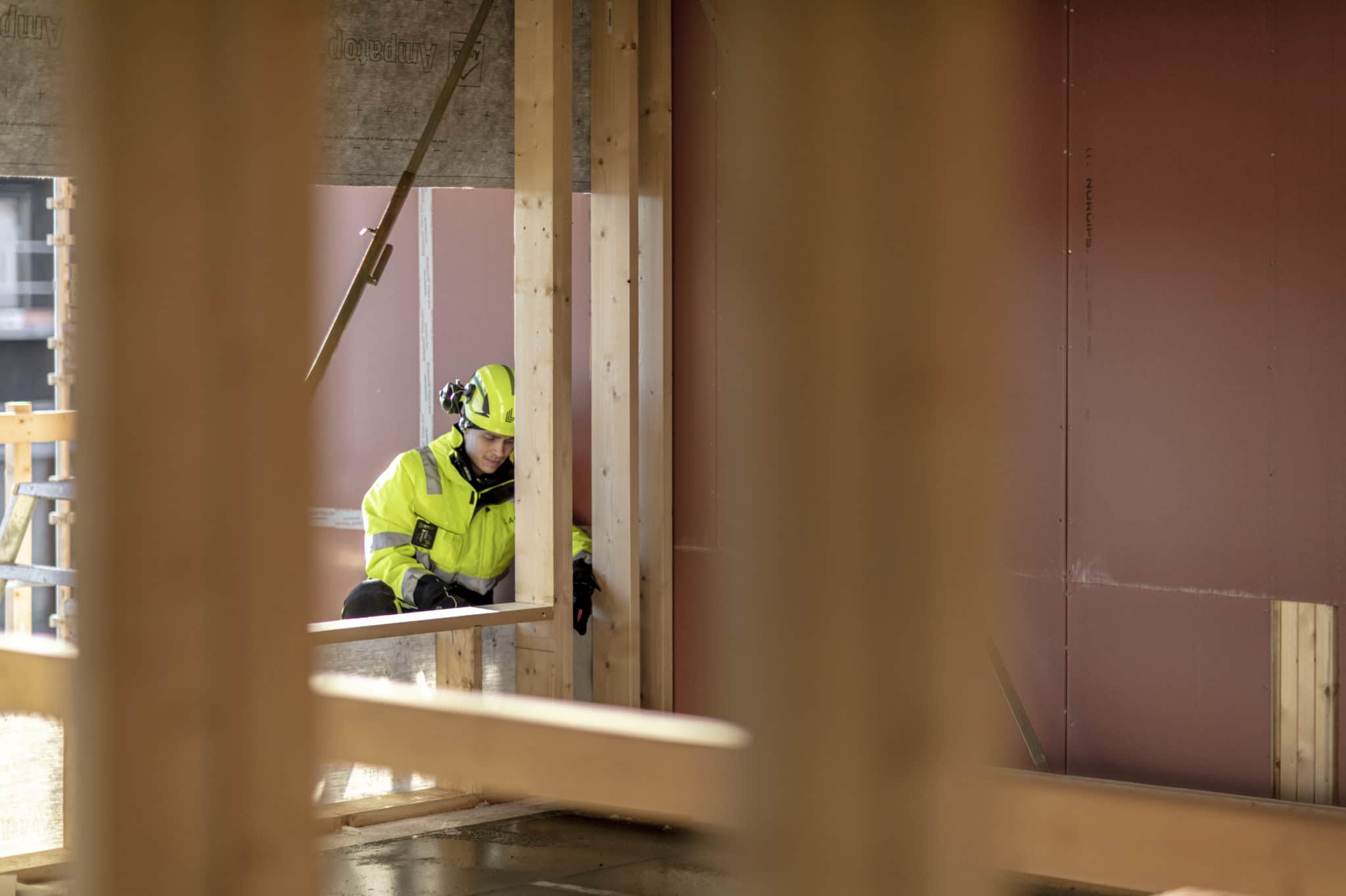 mannlig tømrer bak en vegg