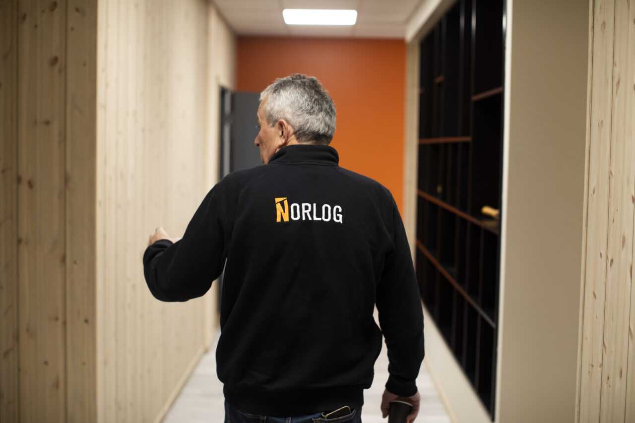 ryggen til en mann som går i en gang med tre på veggene